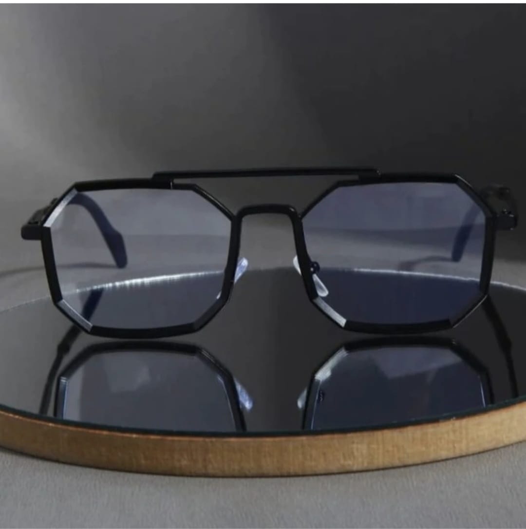 Black sunglasses with a geometric frame on a reflective surface
