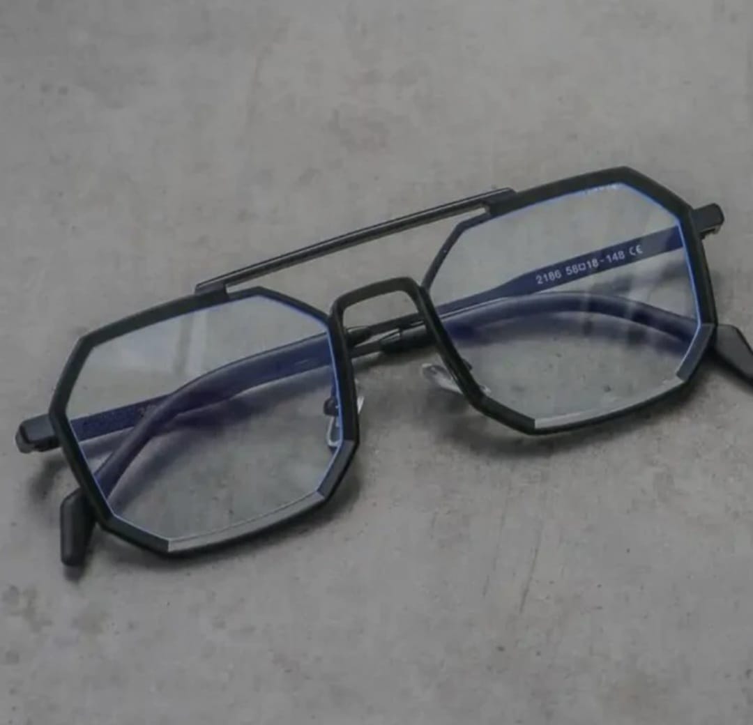 Black eyeglasses with hexagonal lenses on a gray surface